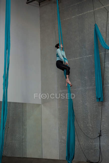 Turnerin turnt im Fitnessstudio auf blauem Stoffseil — Stockfoto