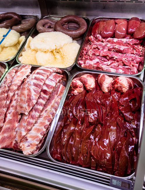 Variety of meat at display counter in butchers shop — Stock Photo