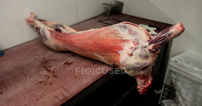 Carcaça de porco mantida na mesa no talho — Fotografia de Stock