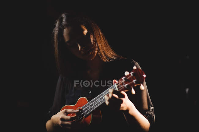 Schöne Frau spielt Gitarre in der Musikschule — Stockfoto