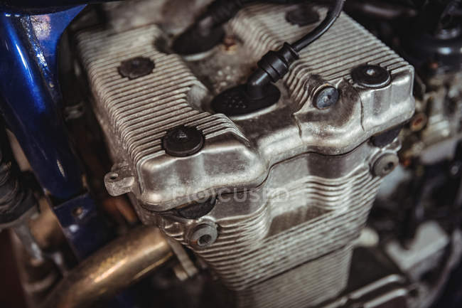 Primer plano de la pieza del motor de la motocicleta en taller - foto de stock