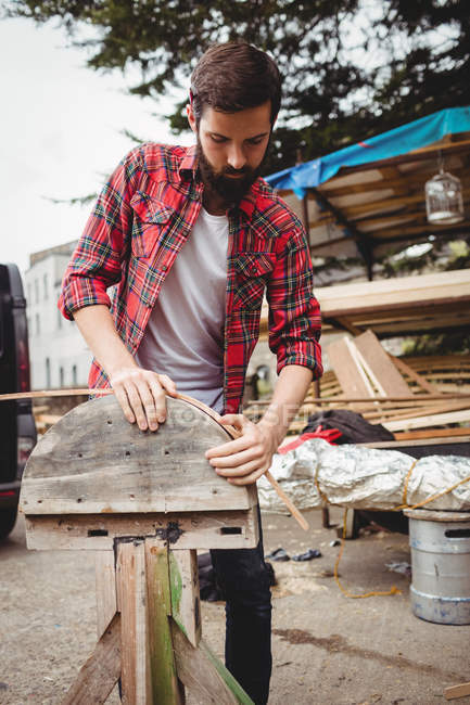 Homem preparando uma moldura de barco de madeira no estaleiro — Fotografia de Stock