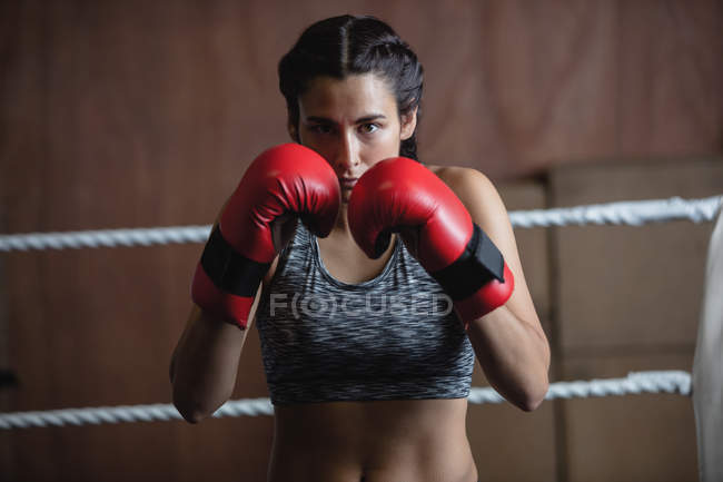 Retrato de mulher confiante em luvas de boxe no estúdio de fitness — Fotografia de Stock