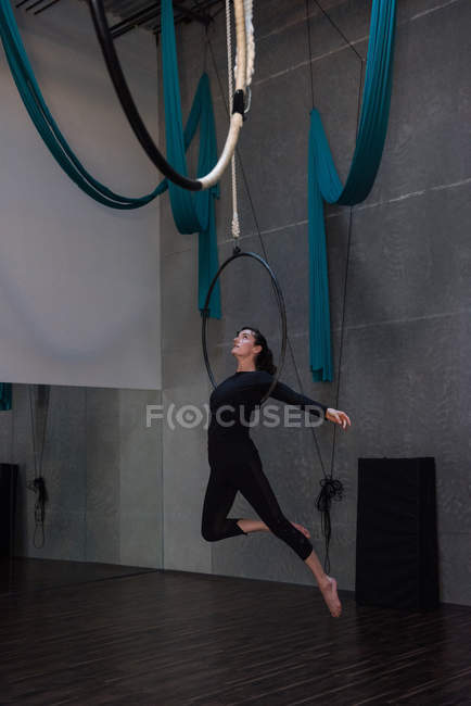 Gymnast performing gymnastics on hoop in fitness studio — Stock Photo