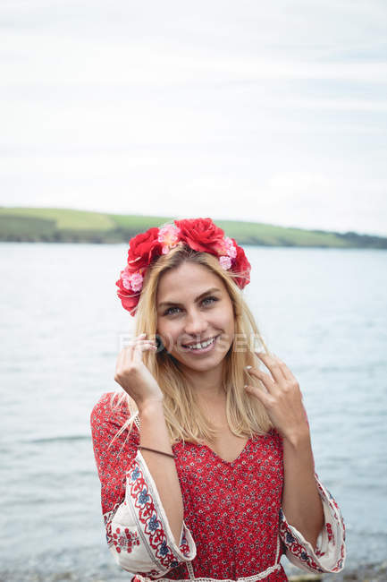 Retrato de mulher loira sorridente em flor tiara de pé perto do rio — Fotografia de Stock