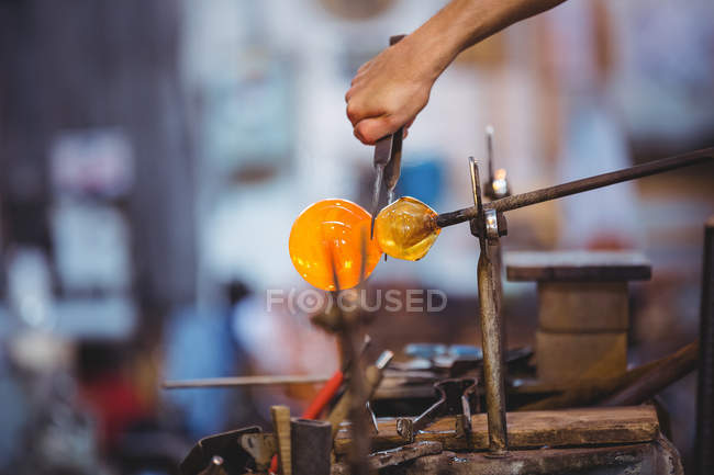 Рука стеклодува, формирующая расплавленное стекло на стекольном заводе — стоковое фото