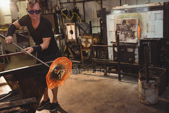 Glassblower shaping molten glass at glassblowing factory — Stock Photo