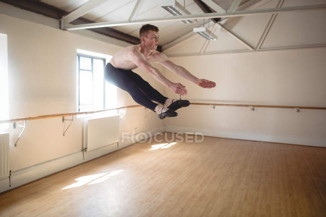 Bailarina practicando danza de ballet y saltando en estudio - foto de stock