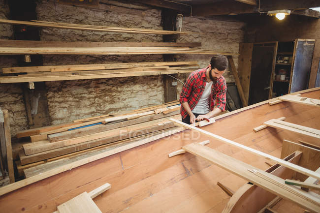 Чоловік готує дерев'яну раму човна на човні — стокове фото