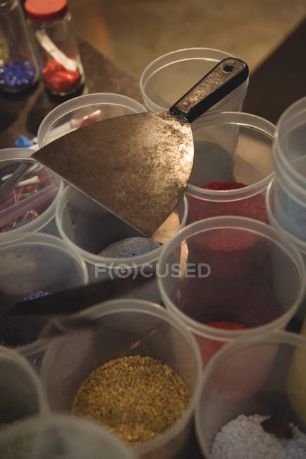 Close-up of frit glass in plastic containers at glassblowing factory — Stock Photo