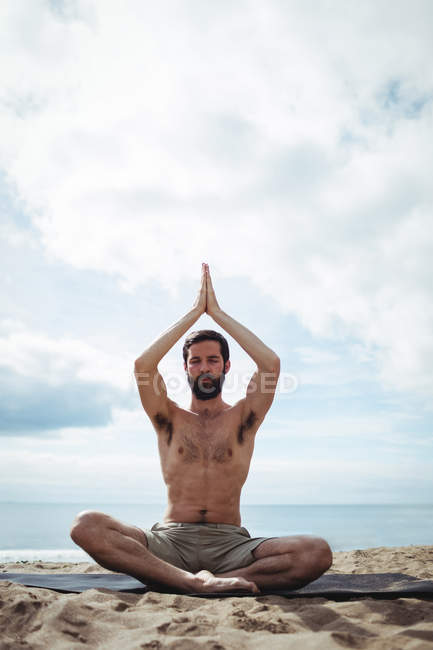 Homem realizando ioga na praia — Fotografia de Stock