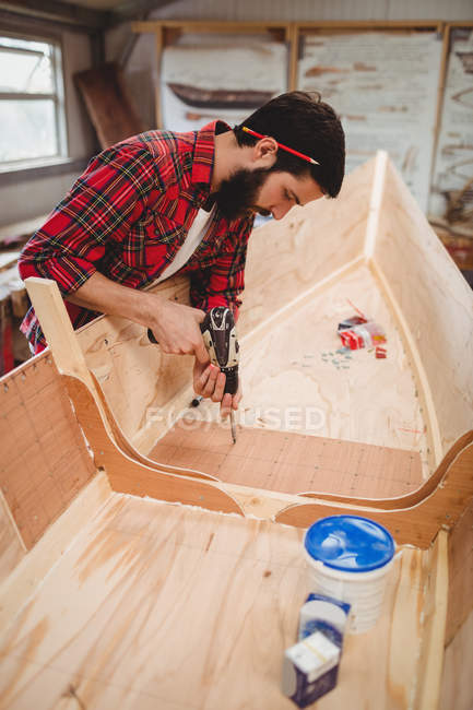 Man preparing a wooden boat frame at boatyard — Stock Photo