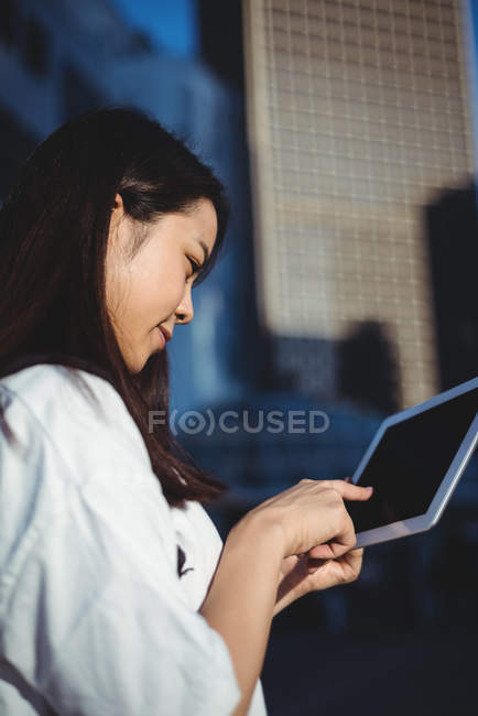 Молодая женщина использует цифровой планшет на улице — стоковое фото