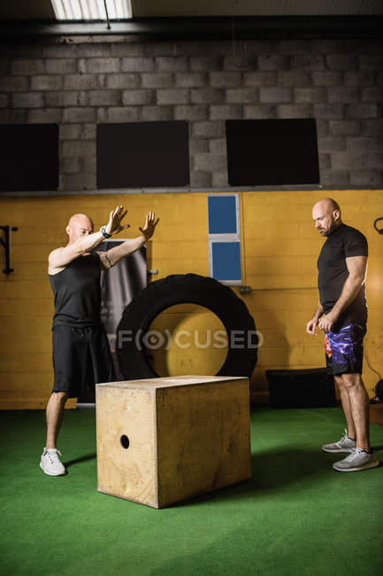Dois desportistas trabalhando em caixa de madeira no estúdio de fitness — Fotografia de Stock