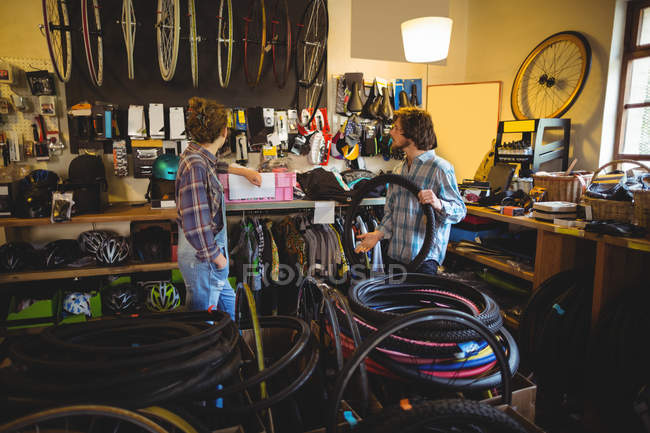 Mechanics selecting tyres in bicycle workshop — Stock Photo