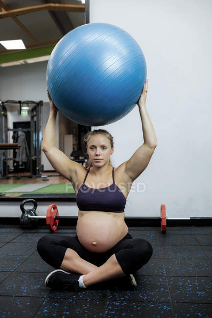 Femme enceinte faisant de l'exercice avec balle d'exercice dans la salle de gym — Photo de stock