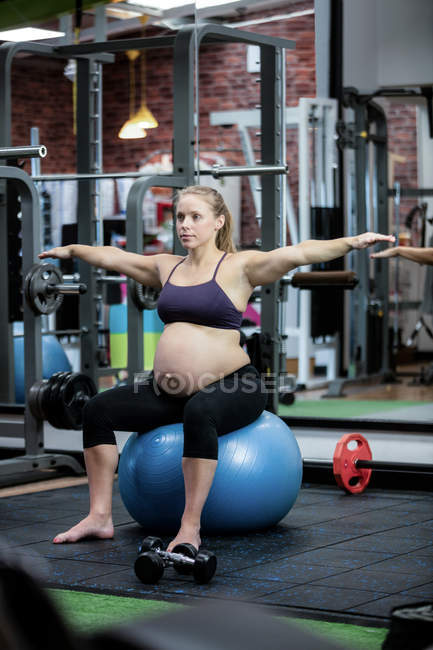 Schwangere beim Stretching auf Fitnessball im Fitnessstudio — Stockfoto