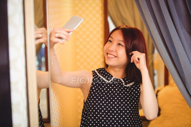 Donna che prende selfie dal cellulare al boutique store — Foto stock