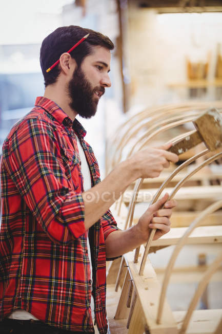 Man preparing wooden boat frame in boatyard — Stock Photo