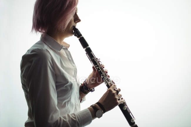 Donna attenta a suonare un clarinetto nella scuola di musica — Foto stock