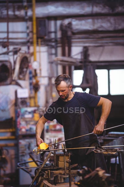 Glassblower forming and shaping a molten glass at glassblowing factory — Stock Photo