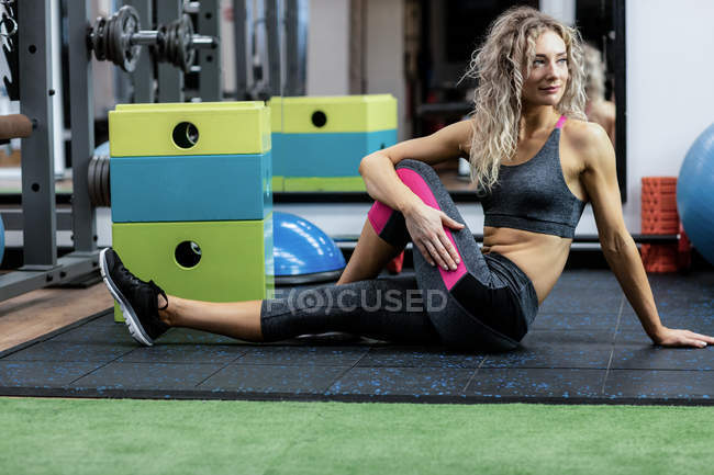 Mulher bonita realizando exercício de alongamento no ginásio — Fotografia de Stock