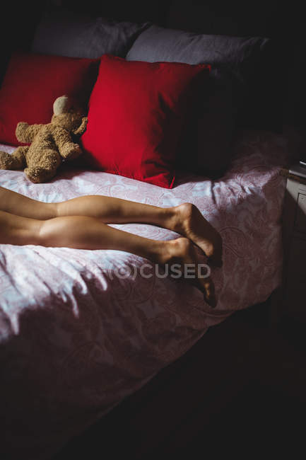 Gambe di donna sdraiata sul letto in camera da letto a casa — Foto stock