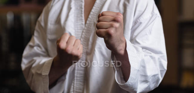 Midsection de l'homme en kimono karaté debout dans un studio de fitness — Photo de stock