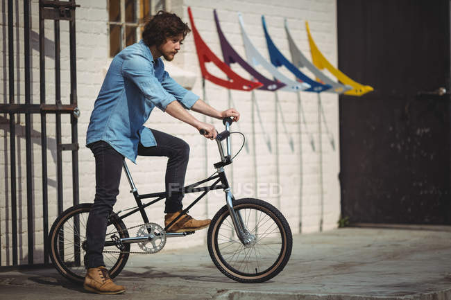 Hombre guapo montando bicicleta en un día soleado - foto de stock