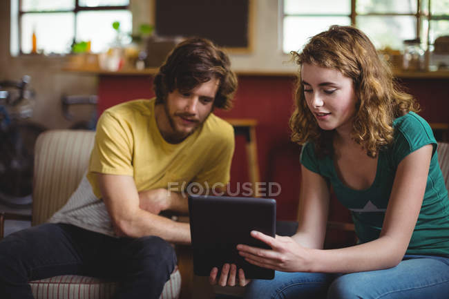 Mechanics sitting on sofa and using digital tablet in workshop — Stock Photo