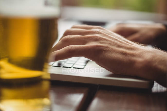 Close-up de homem usando laptop no bar — Fotografia de Stock