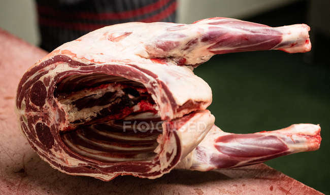 Carcaça de porco mantida na mesa no talho — Fotografia de Stock
