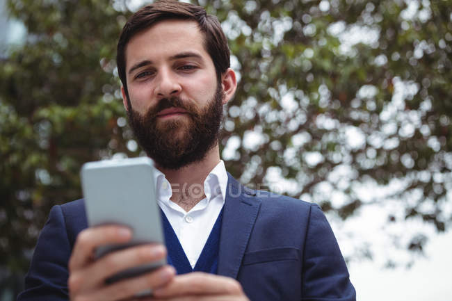 Feliz hombre de negocios usando el teléfono móvil - foto de stock