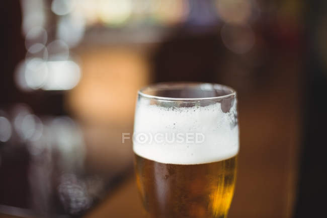 Glass of beer in counter at bar — Stock Photo