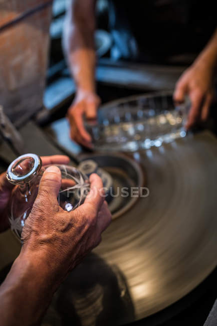 Hands of glassblowers working on a glass at glassblowing factory — Stock Photo