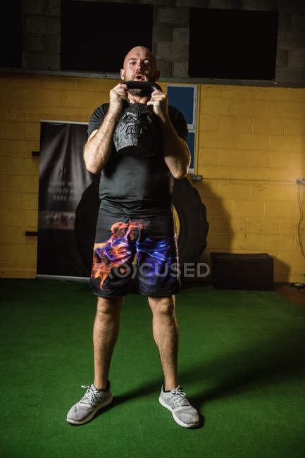 Apuesto deportista levantando peso en el gimnasio - foto de stock