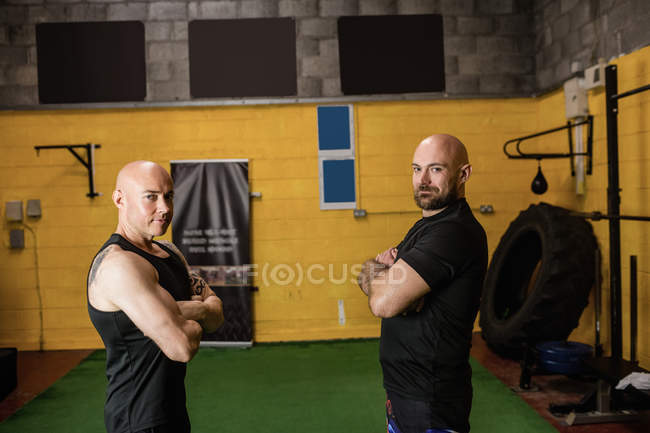 Portrait de boxeurs thaïs confiants debout les bras croisés dans un studio de fitness — Photo de stock