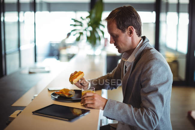 Geschäftsmann frühstückt während der Bürozeiten in Cafeteria — Stockfoto