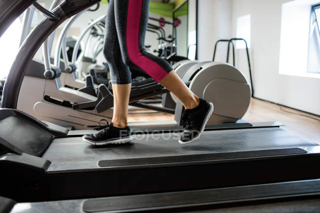 Frau trainiert auf Laufband im Fitnessstudio — Stockfoto