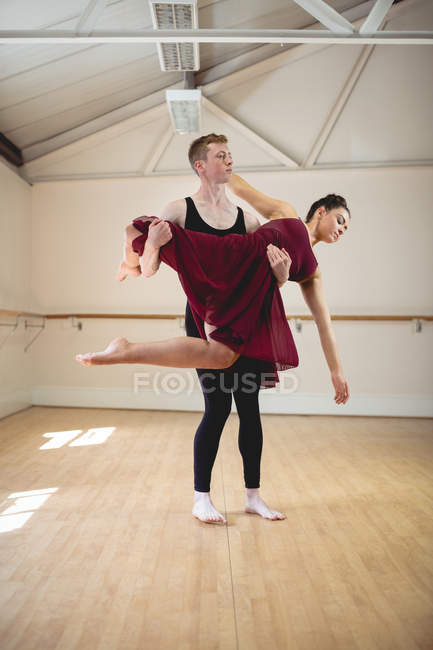Ballerina and ballerino dancing together in modern studio — Stock Photo