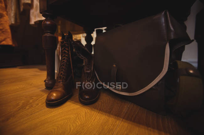 Close-up of antique shoes and bag on wooden floor in antique shop — Stock Photo