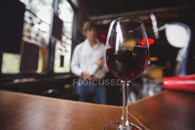 Close-up of glass with red wine on bar counter at bar — Stock Photo