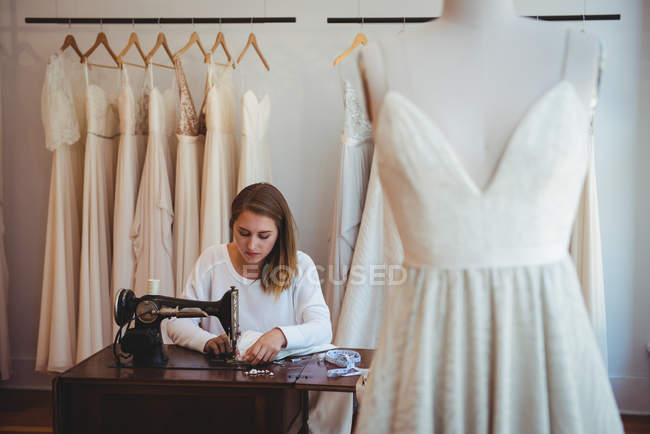 Femme couturière couture sur la machine à coudre en studio — Photo de stock
