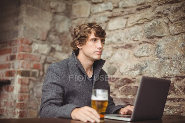 Primo piano dell'uomo con un bicchiere di birra al bar — Foto stock