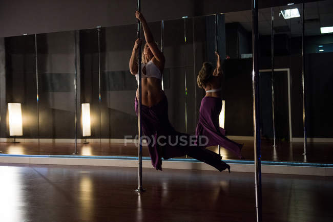 Dançarina de pólo praticando pole dance em estúdio — Fotografia de Stock