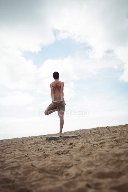 Чоловік виконує розтяжку вправи на пляжі — стокове фото