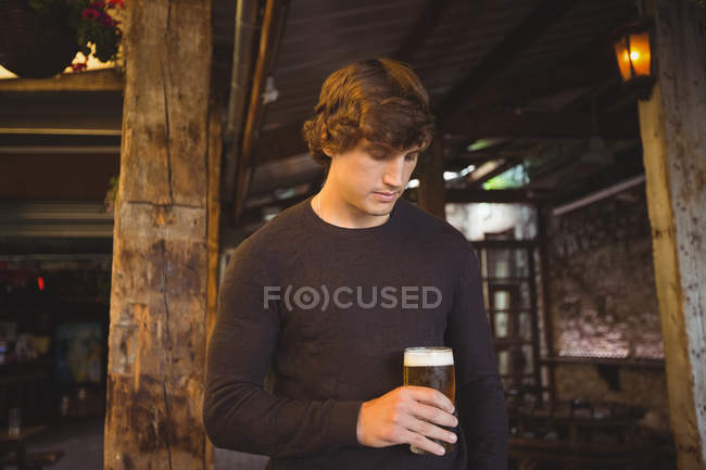 Mann hält Glas Bier an Bar — Stockfoto
