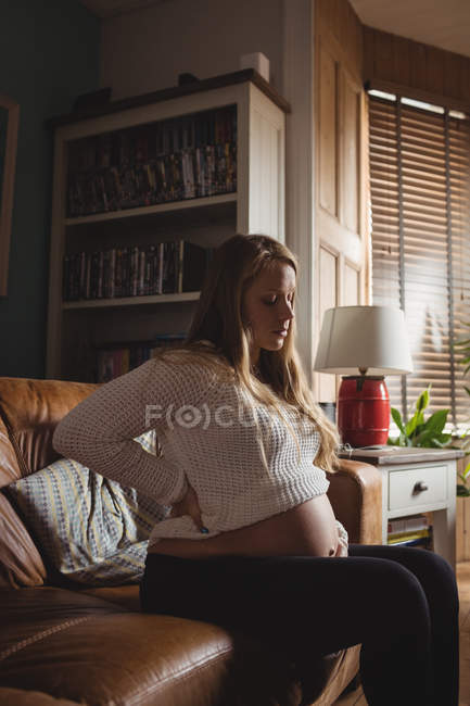 Красива вагітна жінка розслабляється у вітальні вдома — стокове фото