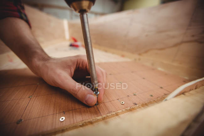 Mão de homem preparando uma moldura de barco de madeira no estaleiro — Fotografia de Stock