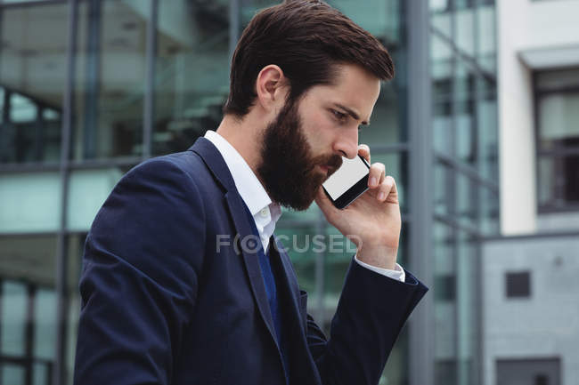 Empresário falando no celular fora do escritório — Fotografia de Stock